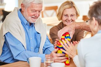 Seniors with dementia interacting at a memory cafe.