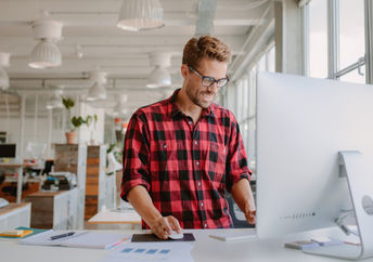 Happy young man working at a standing desk