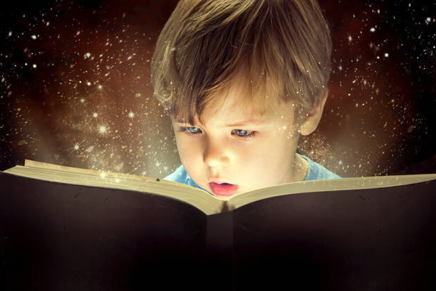 Boy opening a book.