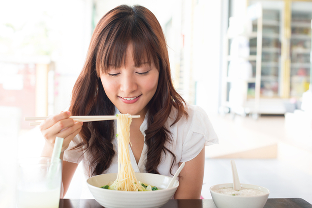 A woman enjoys a bowl of Ramen noodles A woman enjoys a bowl of Ramen noodles