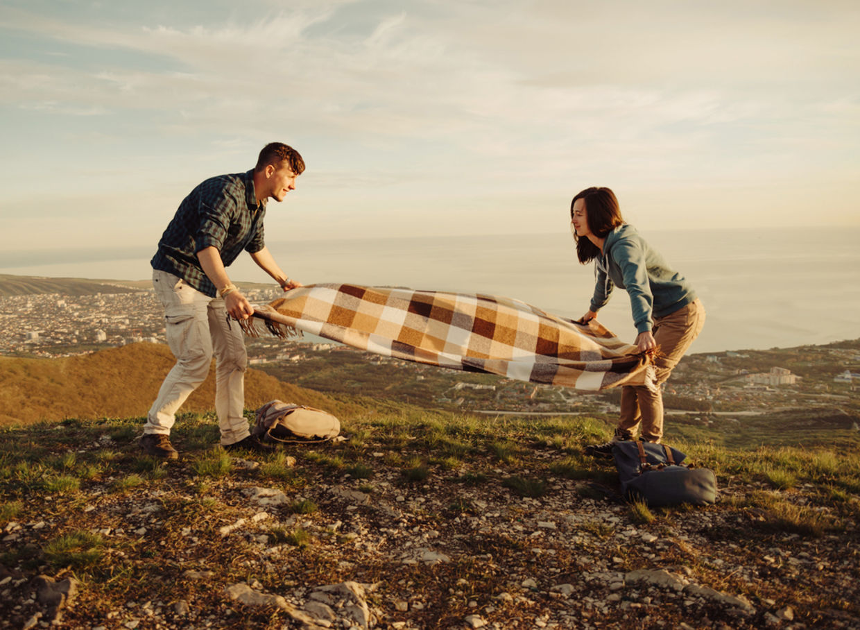 Couple laying blanket down for picnic Couple laying blanket down for picnic