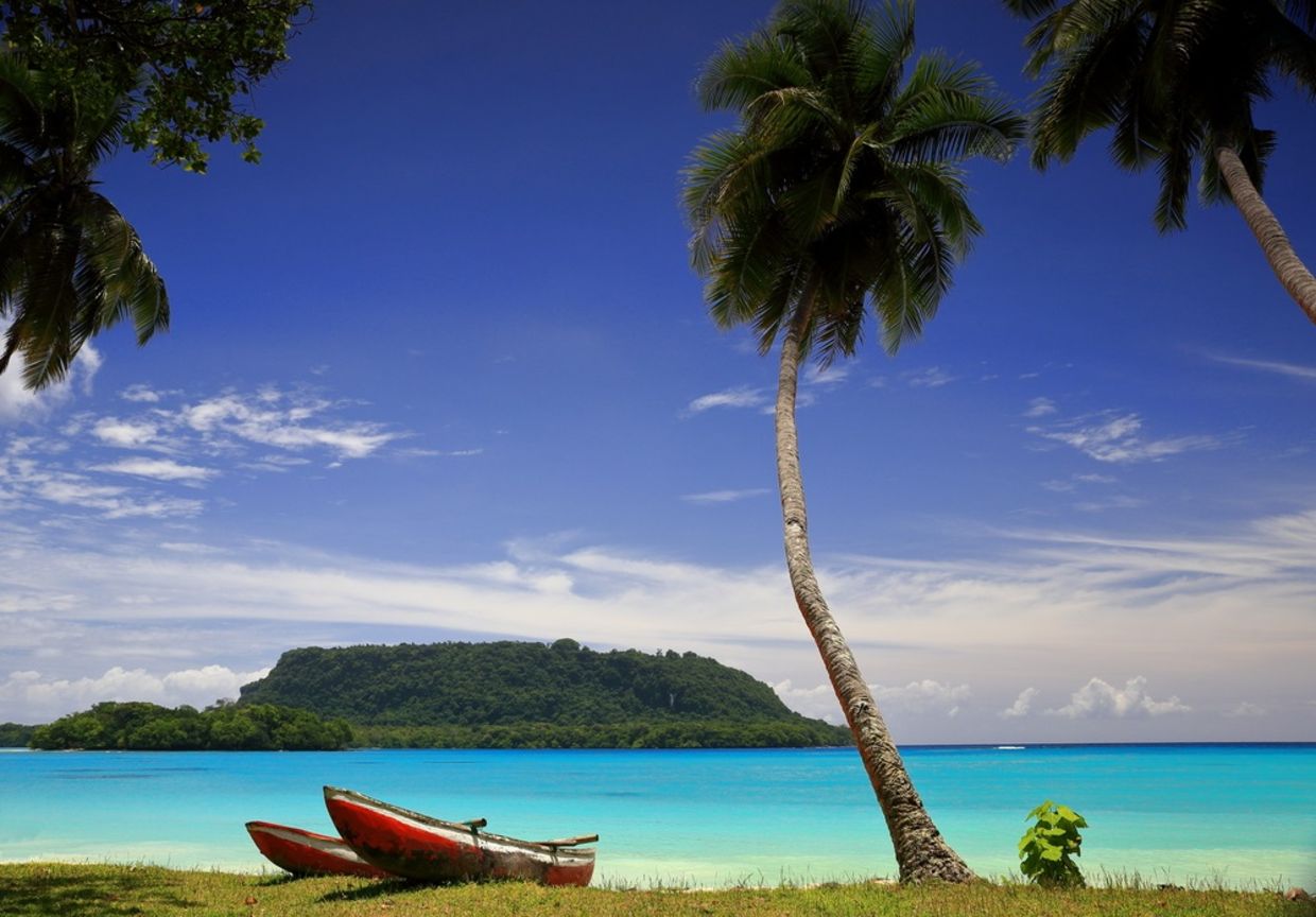 Red canoes sit on the beach in Port Olry, Vanuatu Red canoes sit on the beach in Port Olry, Vanuatu
