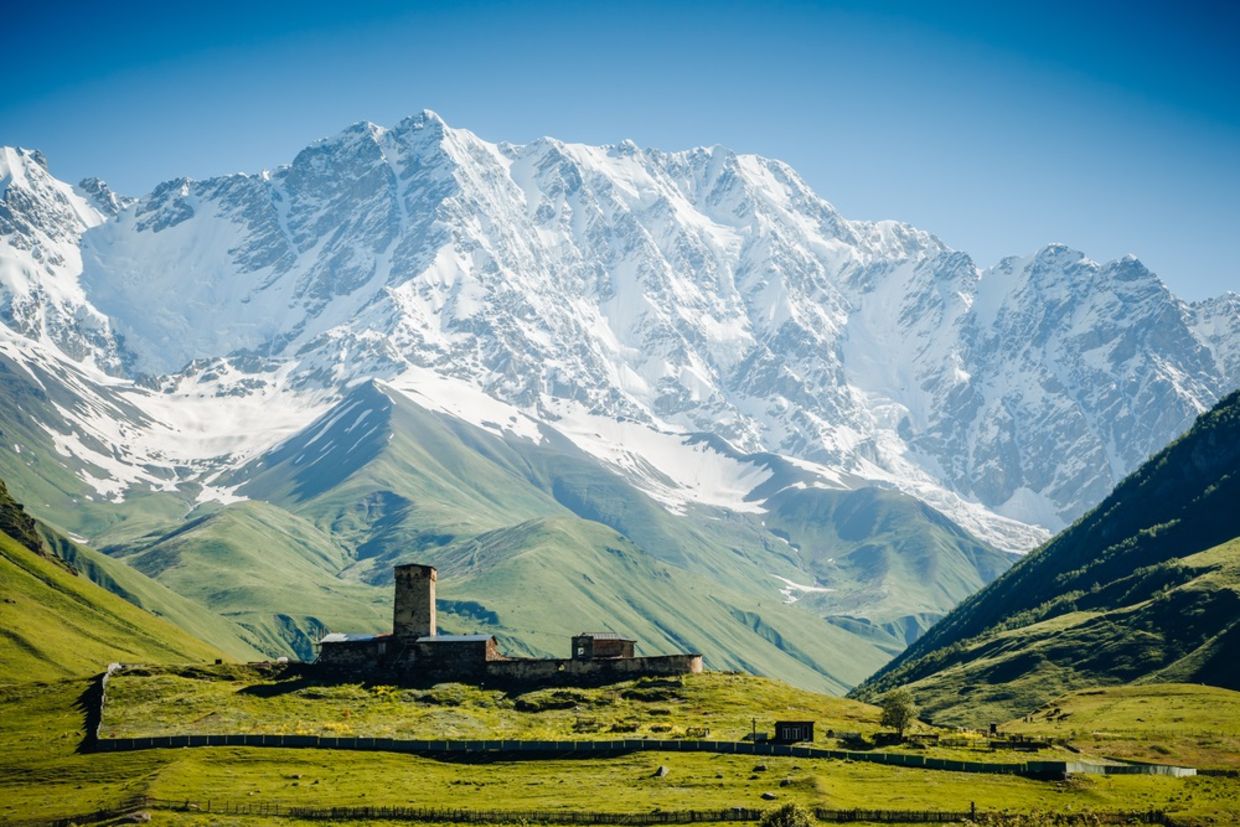 View of Ushguli village and grand ridges that lights up. Location Lamaria Church Jgrag, Upper Svaneti, Georgia, Europe. Main Caucasian Ridge. View of Ushguli village and grand ridges that lights up. Location Lamaria Church Jgrag, Upper Svaneti, Georgia, Europe. Main Caucasian Ridge.