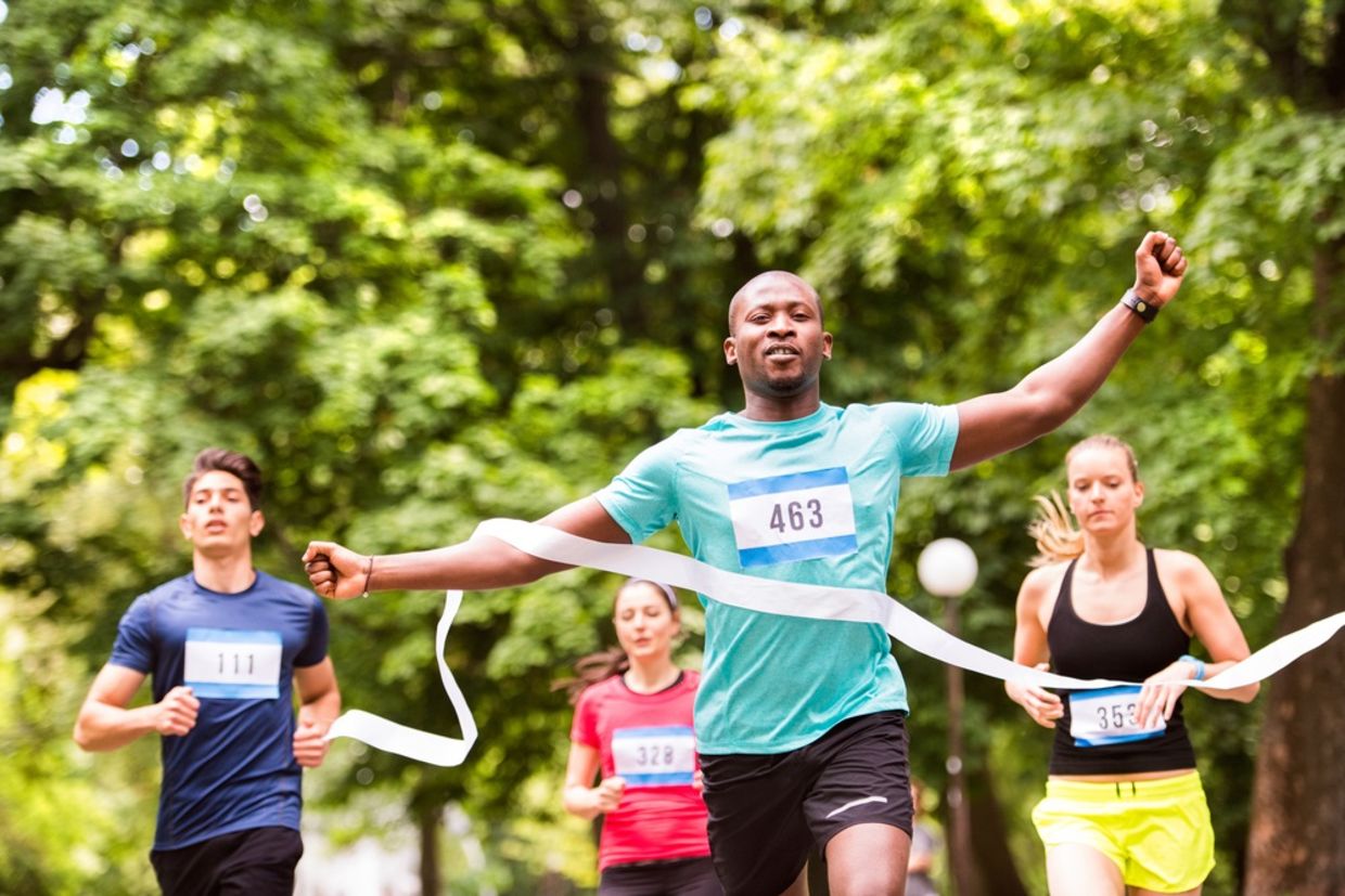 A runner crosses the finish line a ahead of his competitors A runner crosses the finish line a ahead of his competitors