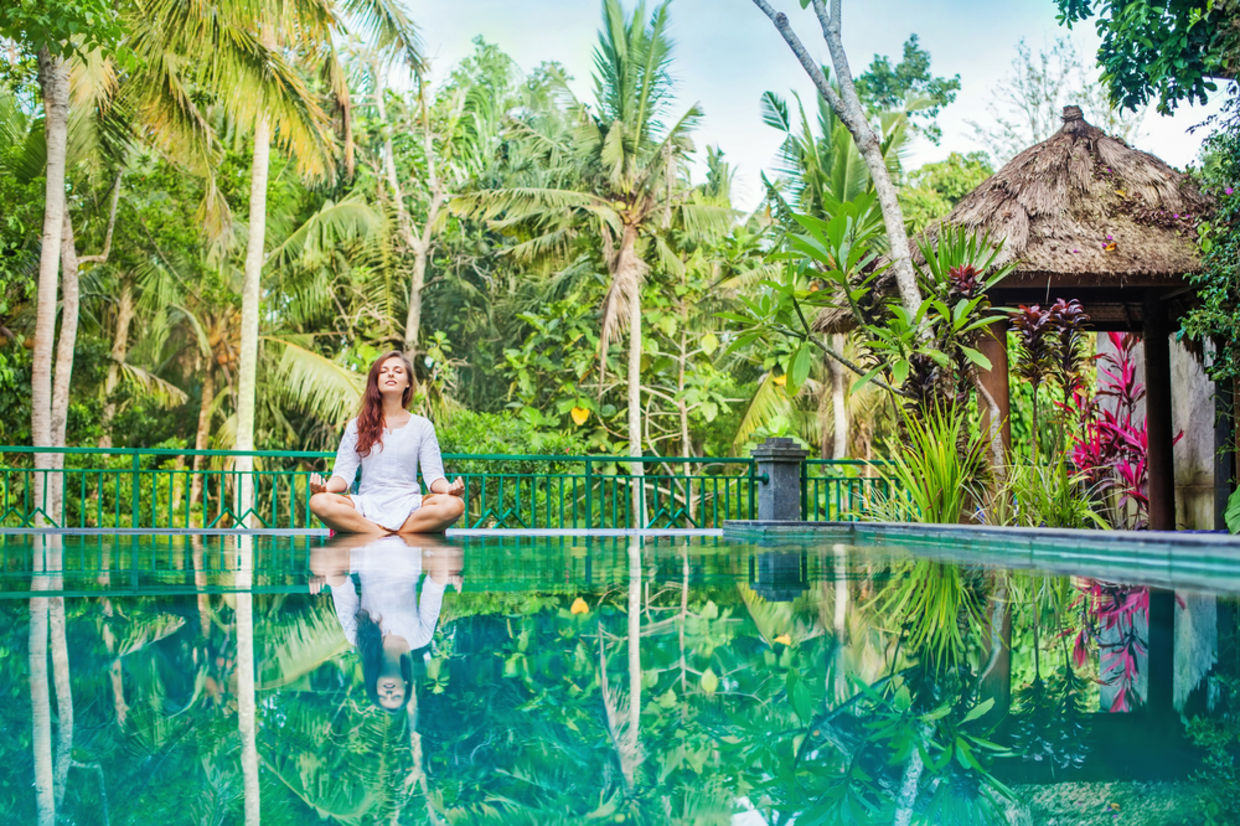 Woman meditation at gorgeous pool side of luxury tropical villa Woman meditation at gorgeous pool side of luxury tropical villa