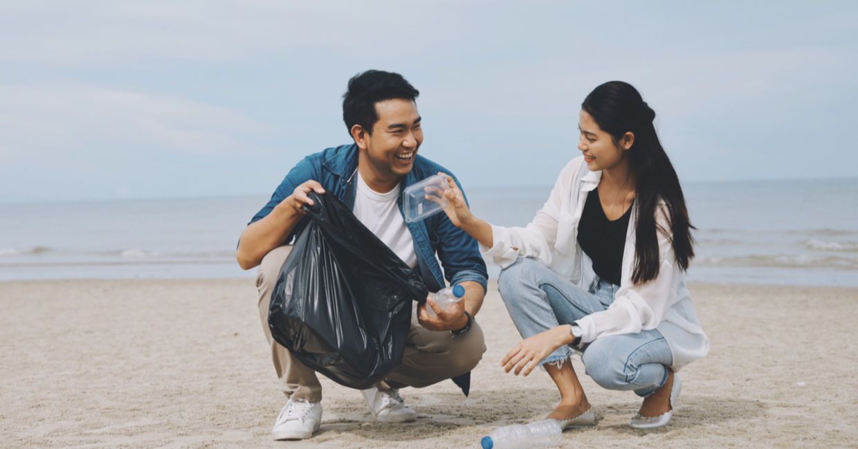 Couple picking up litter together Couple picking up litter together