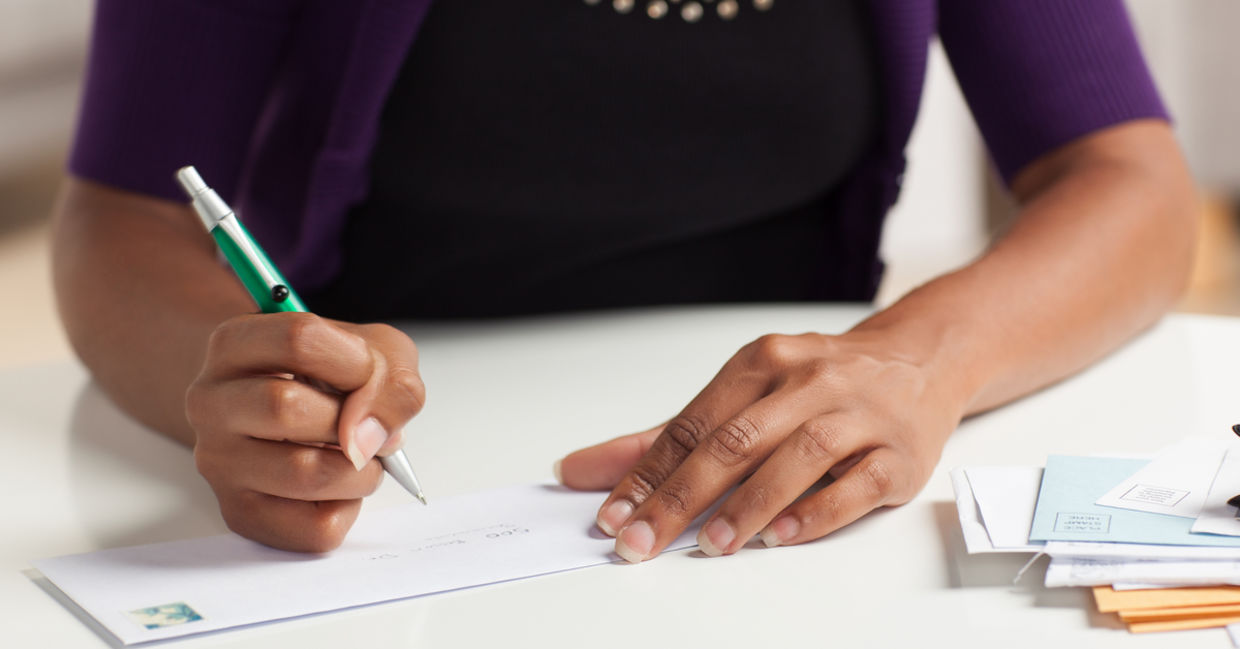 Woman writing check to charity as a good deed