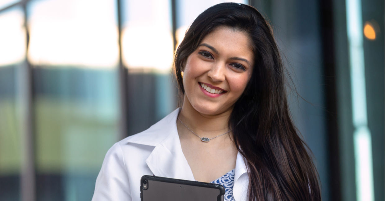 Native American student wearing a white hospital coat. Native American student wearing a white hospital coat.