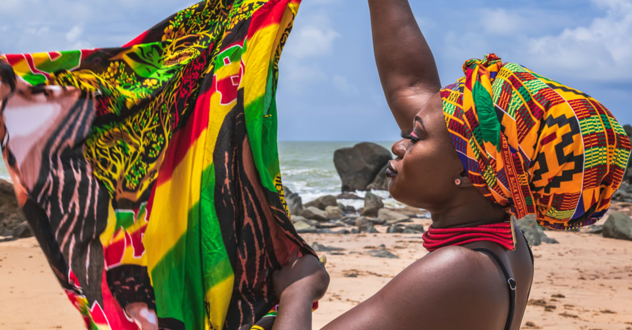 A West African woman holds colorful fabric. A West African woman holds colorful fabric.