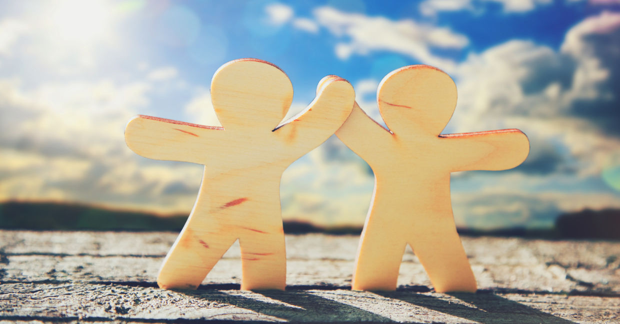 Wooden cutouts holding hands as a symbol of friendship. Wooden cutouts holding hands as a symbol of friendship.