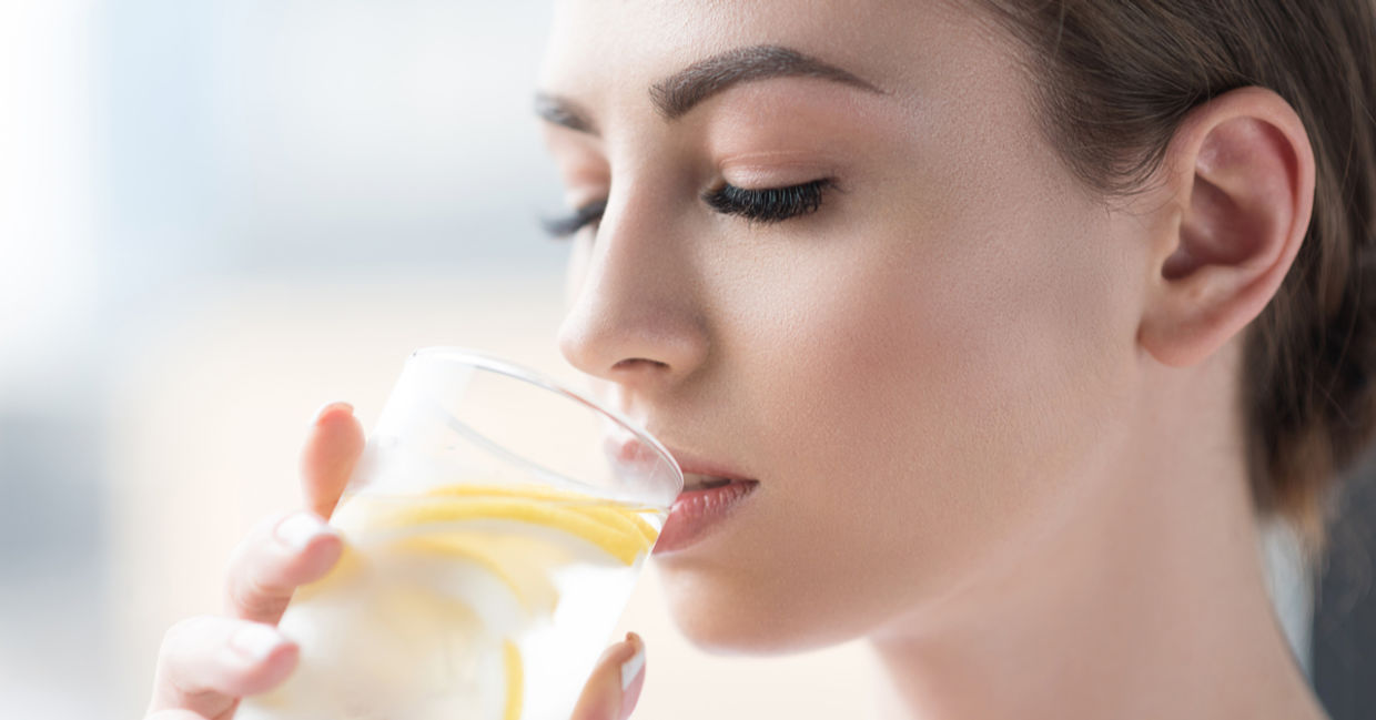 Woman drinking refreshing lemon water. Woman drinking refreshing lemon water.
