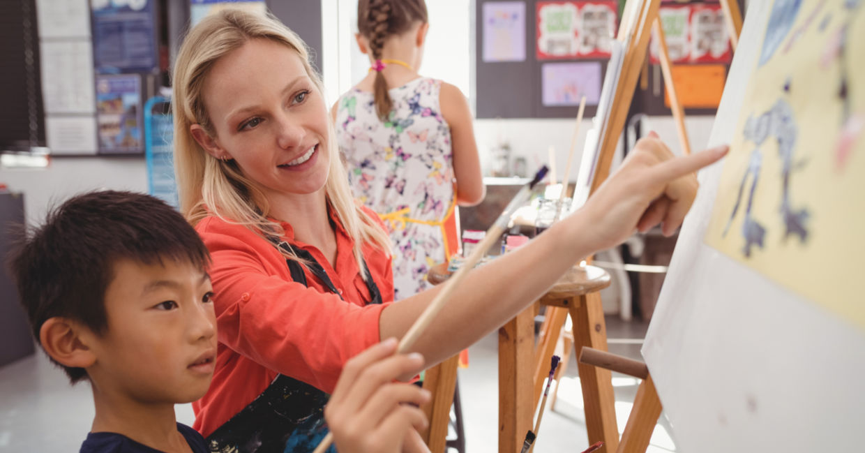 An elementary school art teacher with a student. An elementary school art teacher with a student.
