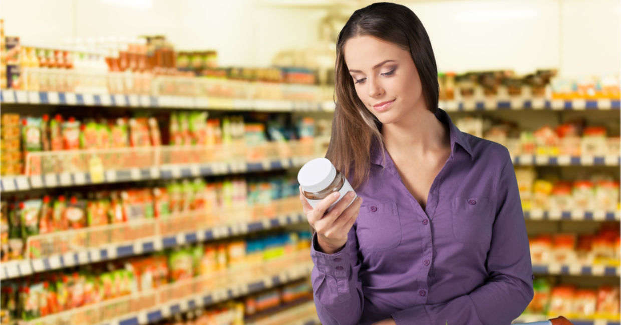 Woman reading food label in supermarket Woman reading food label in supermarket