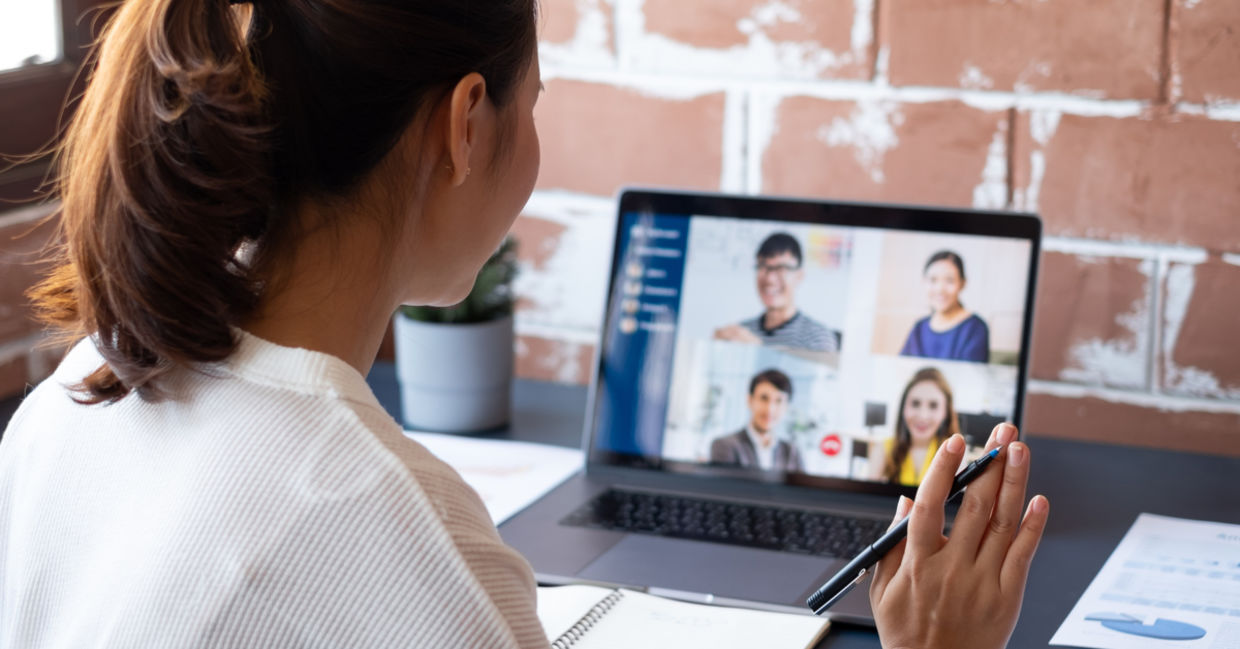 Female worker participating in remote video meeting with colleagues Female worker participating in remote video meeting with colleagues