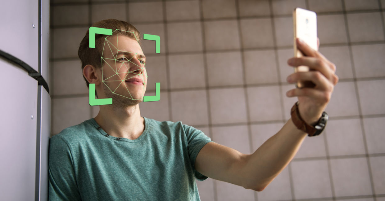 Man scanning face with smartphone Man scanning face with smartphone