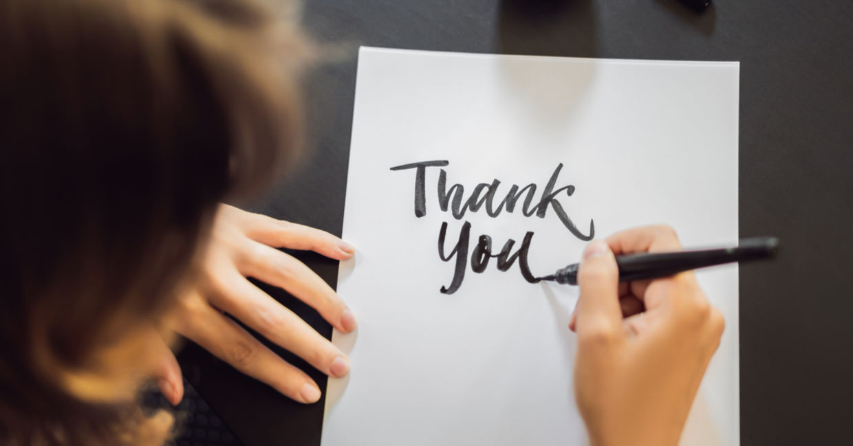 A woman shows gratitude by writing a thank you note. A woman shows gratitude by writing a thank you note.