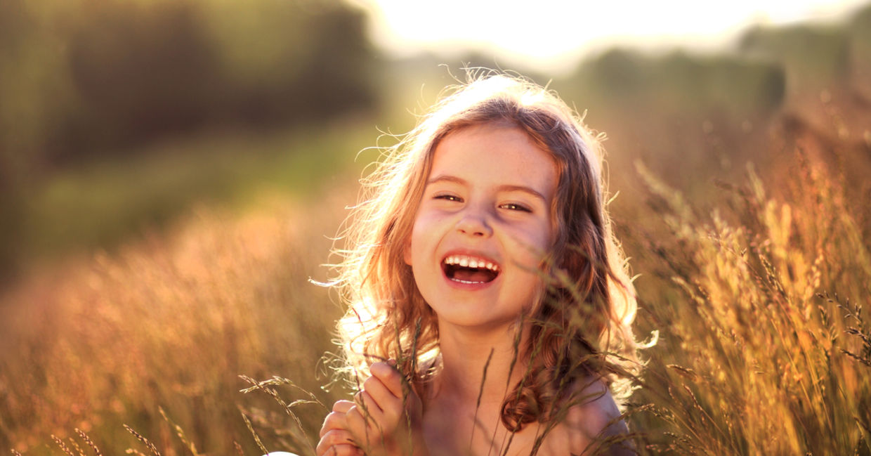 Girl laughing in meadow Girl laughing in meadow