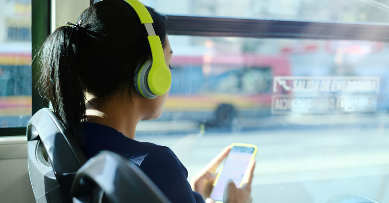 Woman listening to podcast on bus Woman listening to podcast on bus