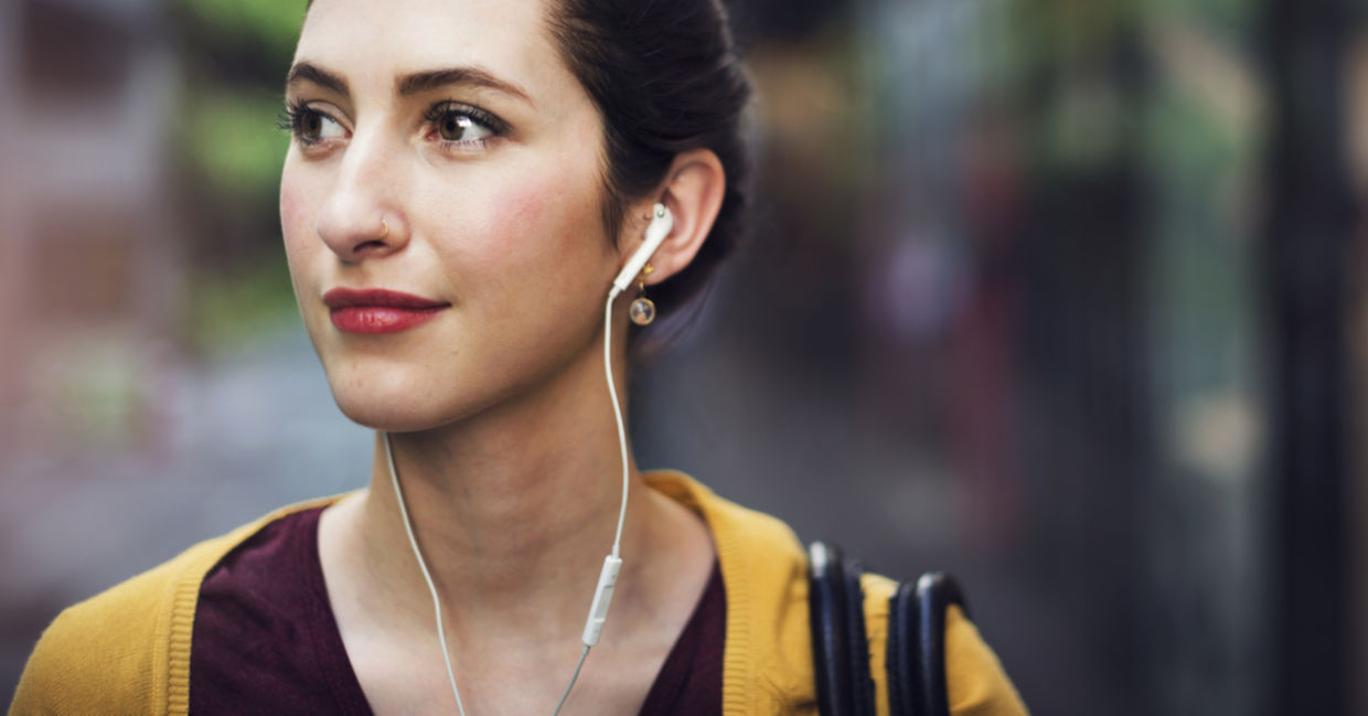 Woman walking and listening to a podcast Woman walking and listening to a podcast