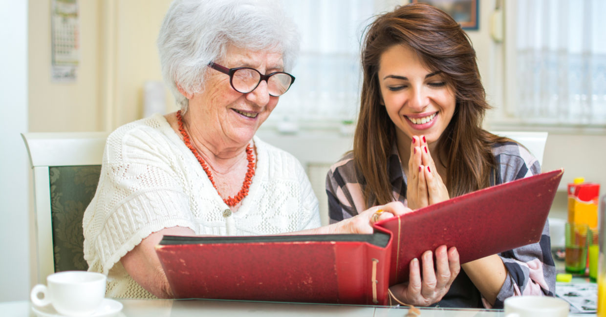 granddaughter looks at photos with grandmother granddaughter looks at photos with grandmother