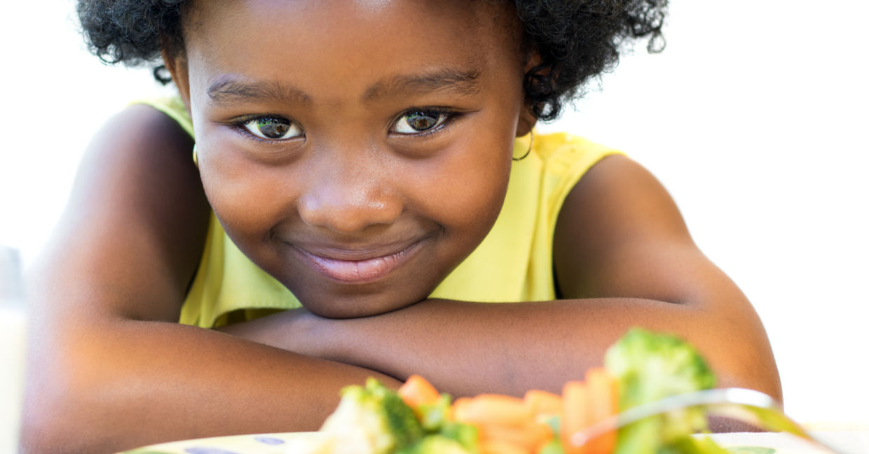 A young girl with a plate of healthy food smiles. A young girl with a plate of healthy food smiles.