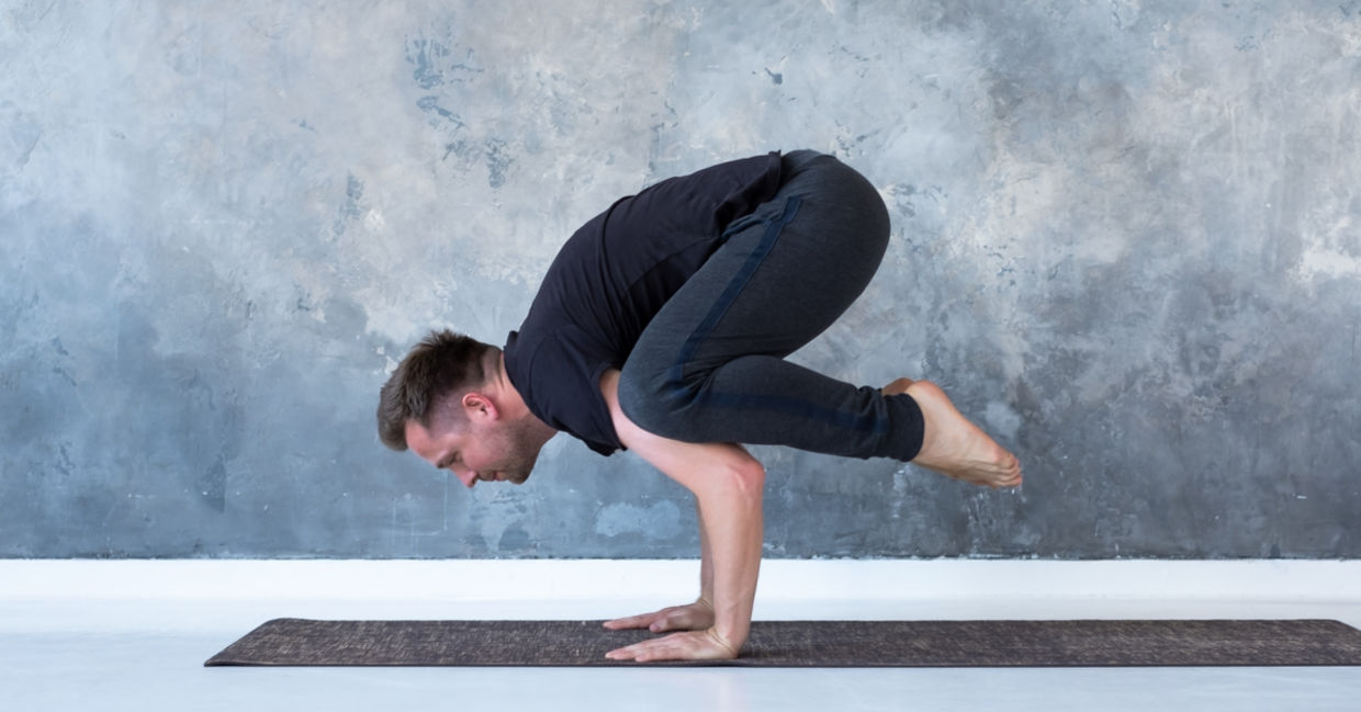 Man performing the crow yoga pose. Man performing the crow yoga pose.
