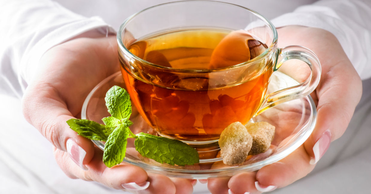 A woman holding a cup of headache soothing tea. A woman holding a cup of headache soothing tea.