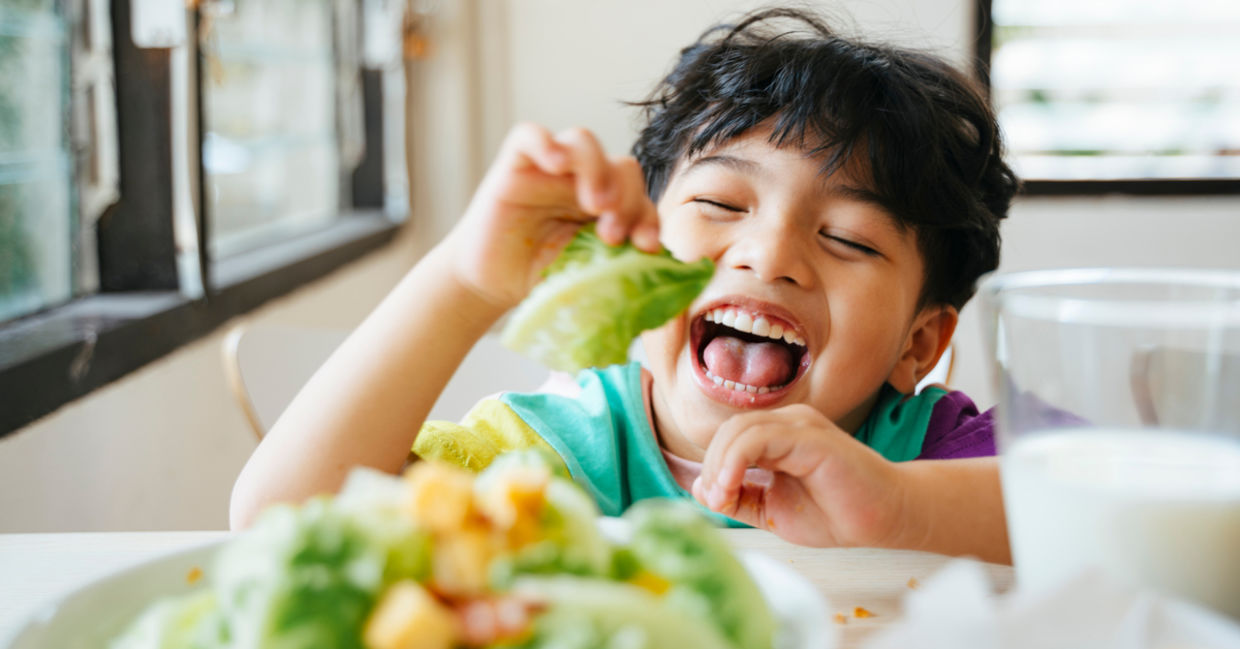 A boy enjoying his food A boy enjoying his food