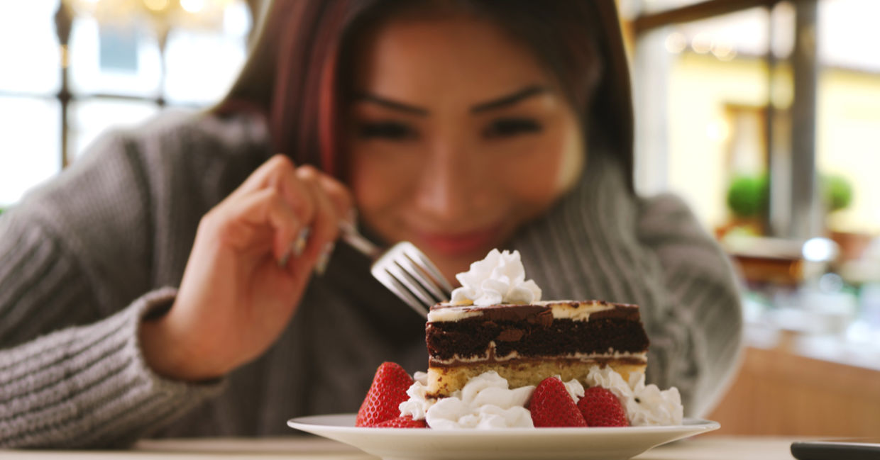 A woman happily indulges in a fancy dessert. A woman happily indulges in a fancy dessert.