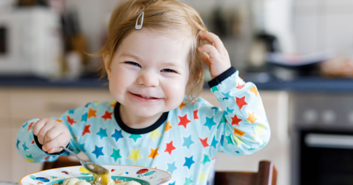 Happy girl eating chicken noodle soup made with a healthy recipe for kids. Happy girl eating chicken noodle soup made with a healthy recipe for kids.