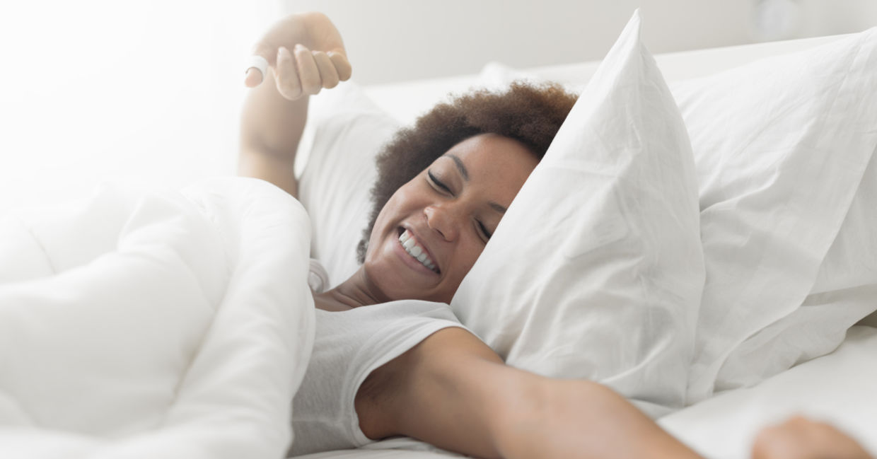 A woman wakes up in the morning smiling. A woman wakes up in the morning smiling.