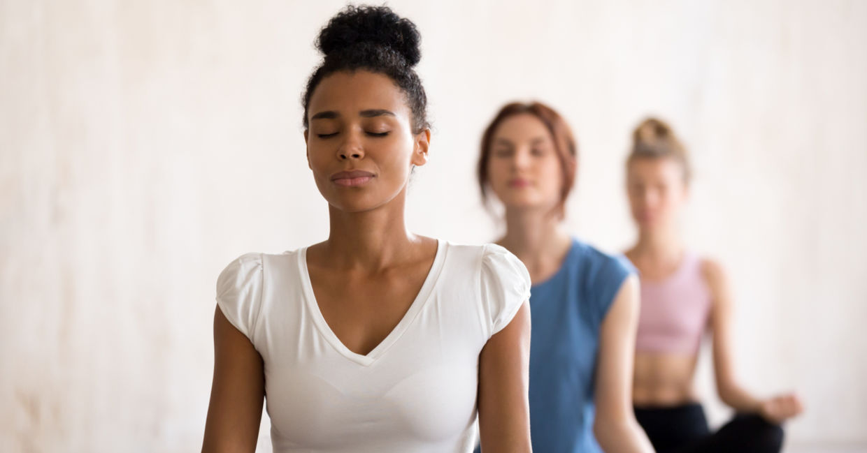 Women of diverse backgrounds meditate together. Women of diverse backgrounds meditate together.