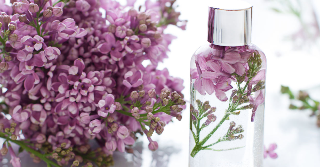 Bottle of spray with lilac flowers. Bottle of spray with lilac flowers.