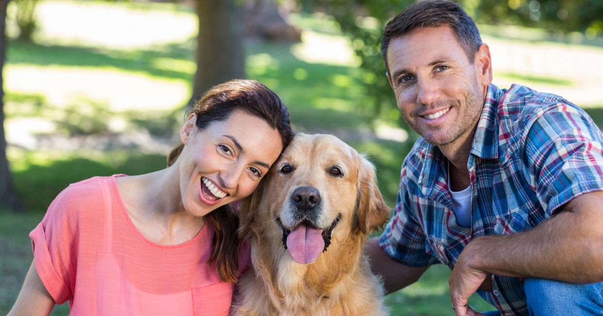 Happy couple with their dog in the park Happy couple with their dog in the park