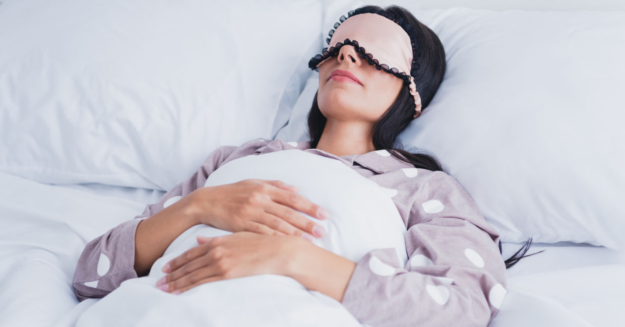 A woman wearing an eye mask is sleeping. A woman wearing an eye mask is sleeping.