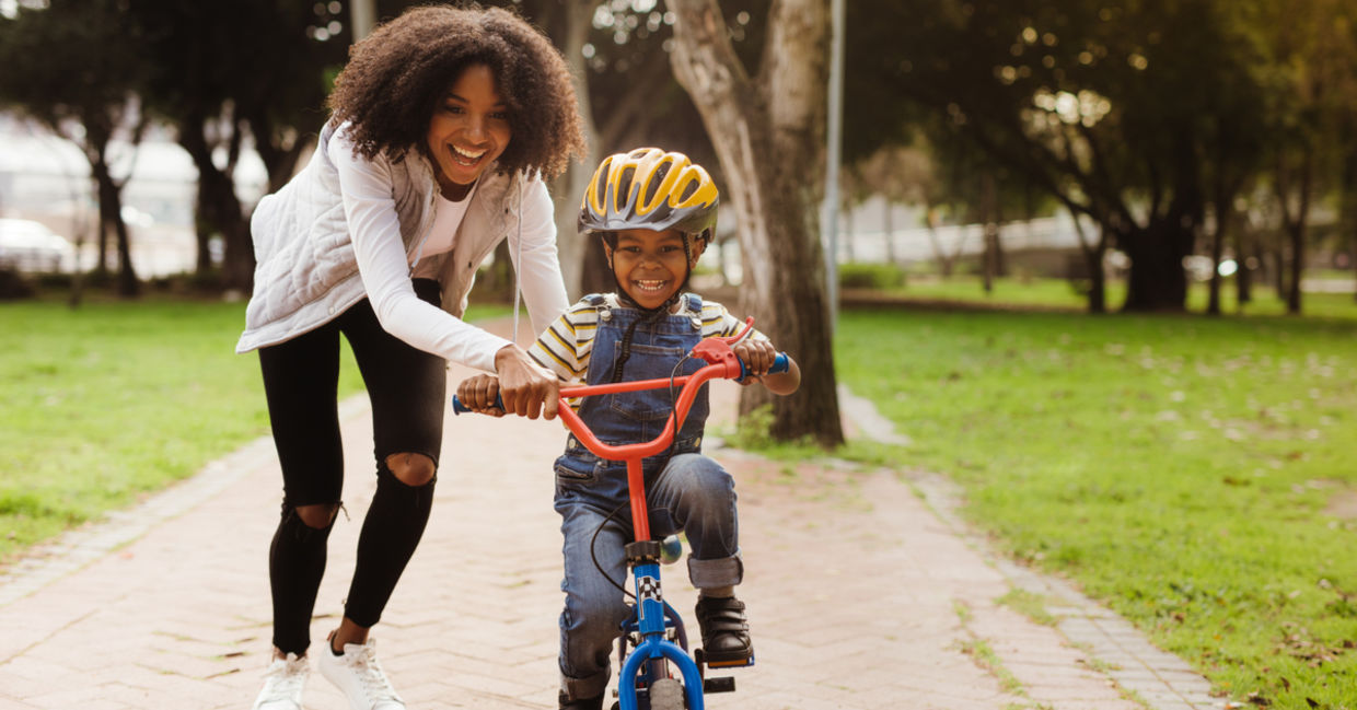 A mother teaching her child how to ride a bicycle. A mother teaching her child how to ride a bicycle.
