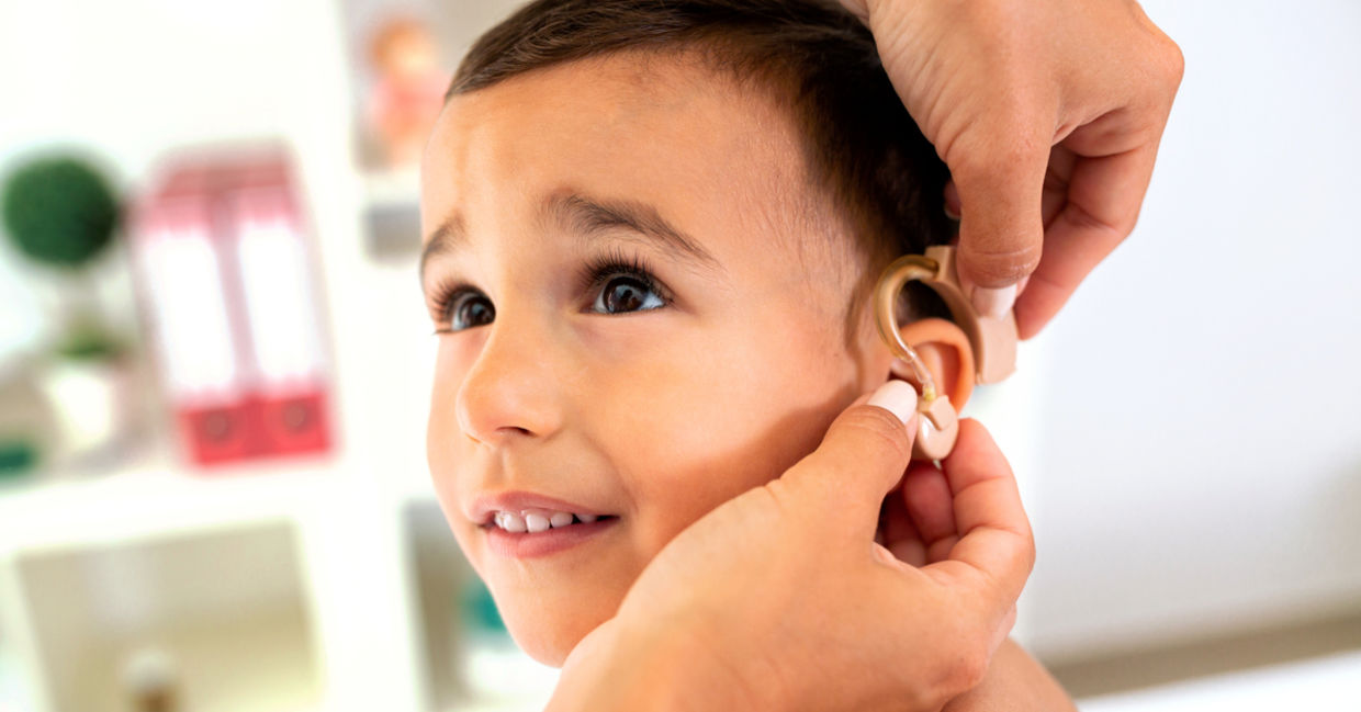 Boy being fitted for a hearing aid. Boy being fitted for a hearing aid.