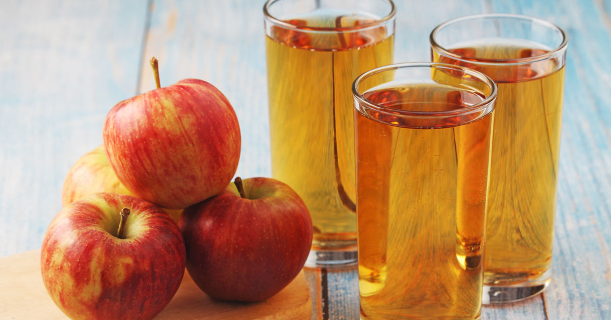 Glasses of homemade apple juice placed beside apples. Glasses of homemade apple juice placed beside apples.