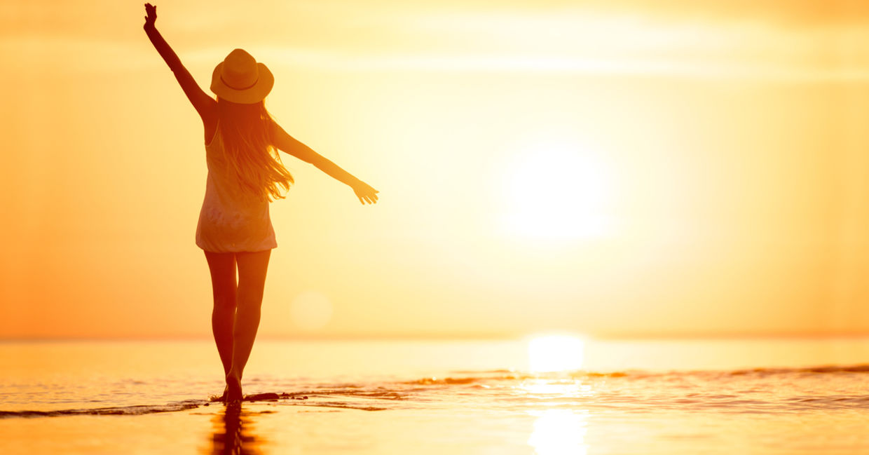 Woman walking on the beach at sunset. Woman walking on the beach at sunset.