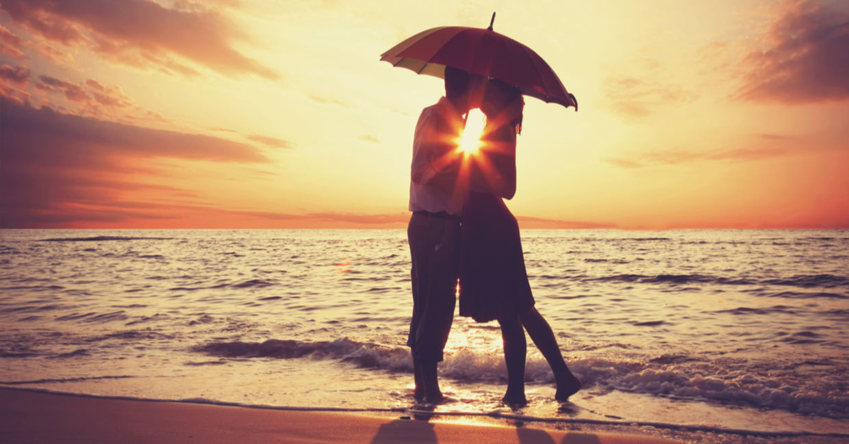 Couple kissing under an umbrella. Couple kissing under an umbrella.