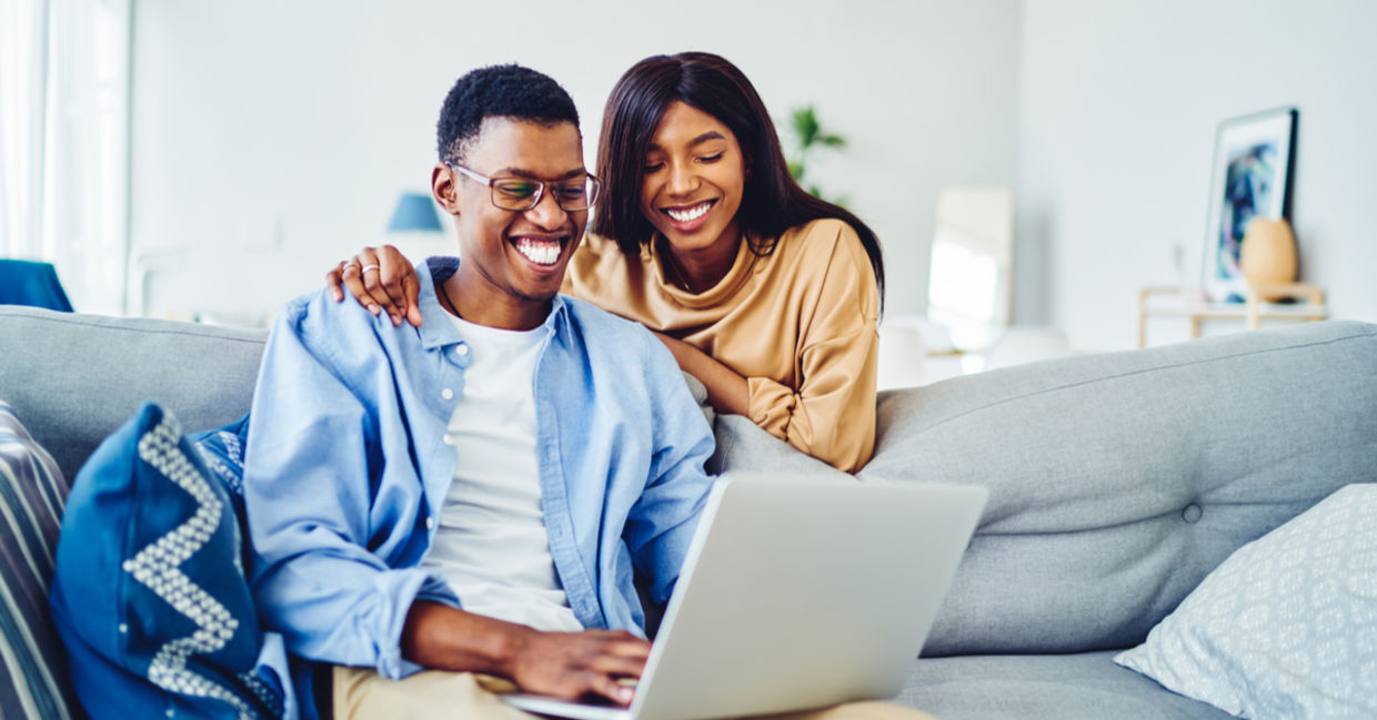 A couple looking at a website on their computer. A couple looking at a website on their computer.