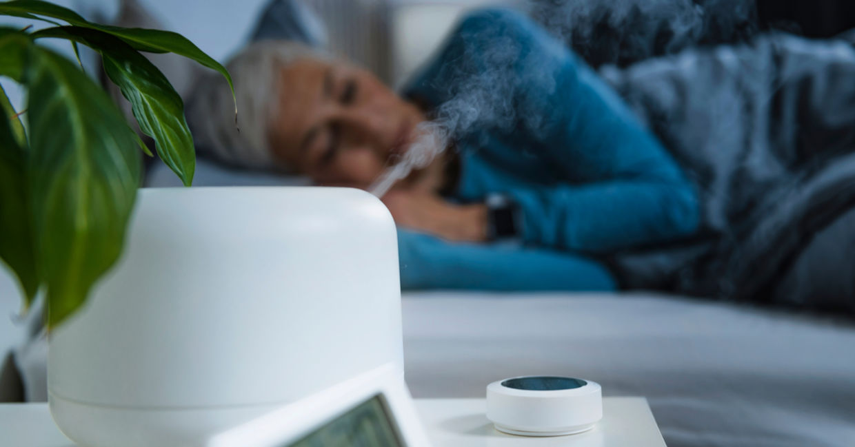 Woman sleeping in bedroom with a humidifier working. Woman sleeping in bedroom with a humidifier working.