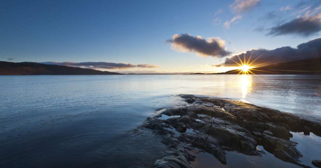 Beautiful sunset over a rocky lake in Scotland promotes spirituality. Beautiful sunset over a rocky lake in Scotland promotes spirituality.