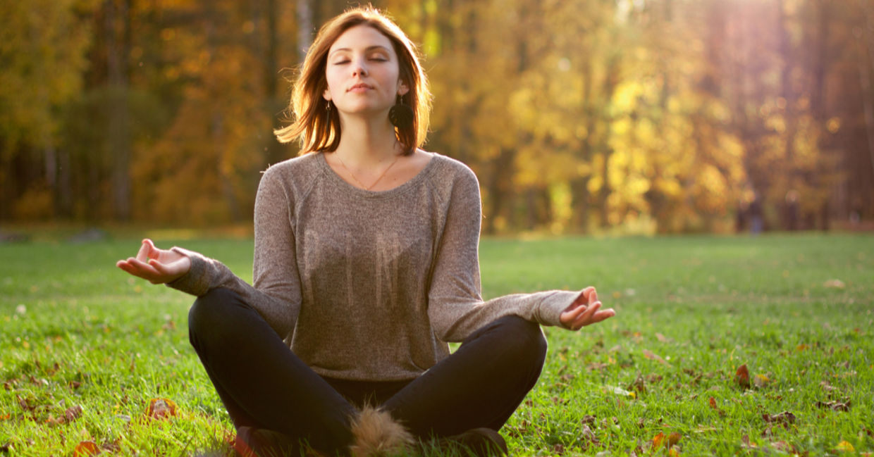 Young woman meditating near trees Young woman meditating near trees