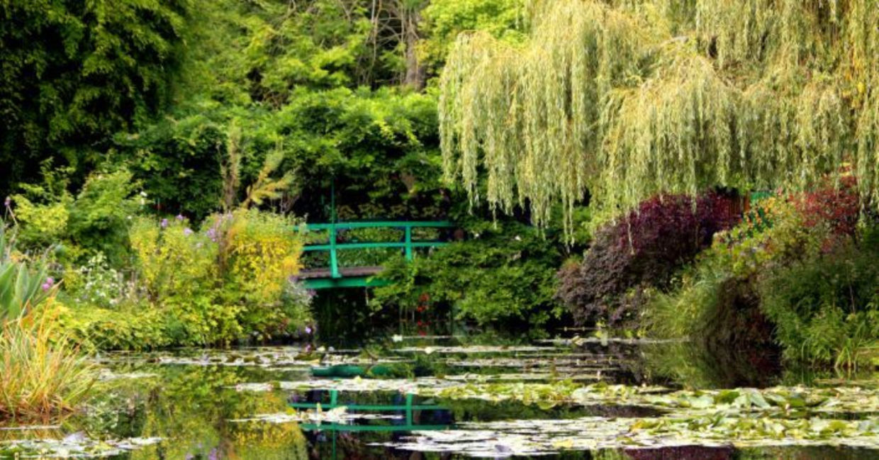 The iconic green Japanese bridge reflecting in the water lily pond in Claude Monet's Garden of Giverny, Normandy, France The iconic green Japanese bridge reflecting in the water lily pond in Claude Monet's Garden of Giverny, Normandy, France