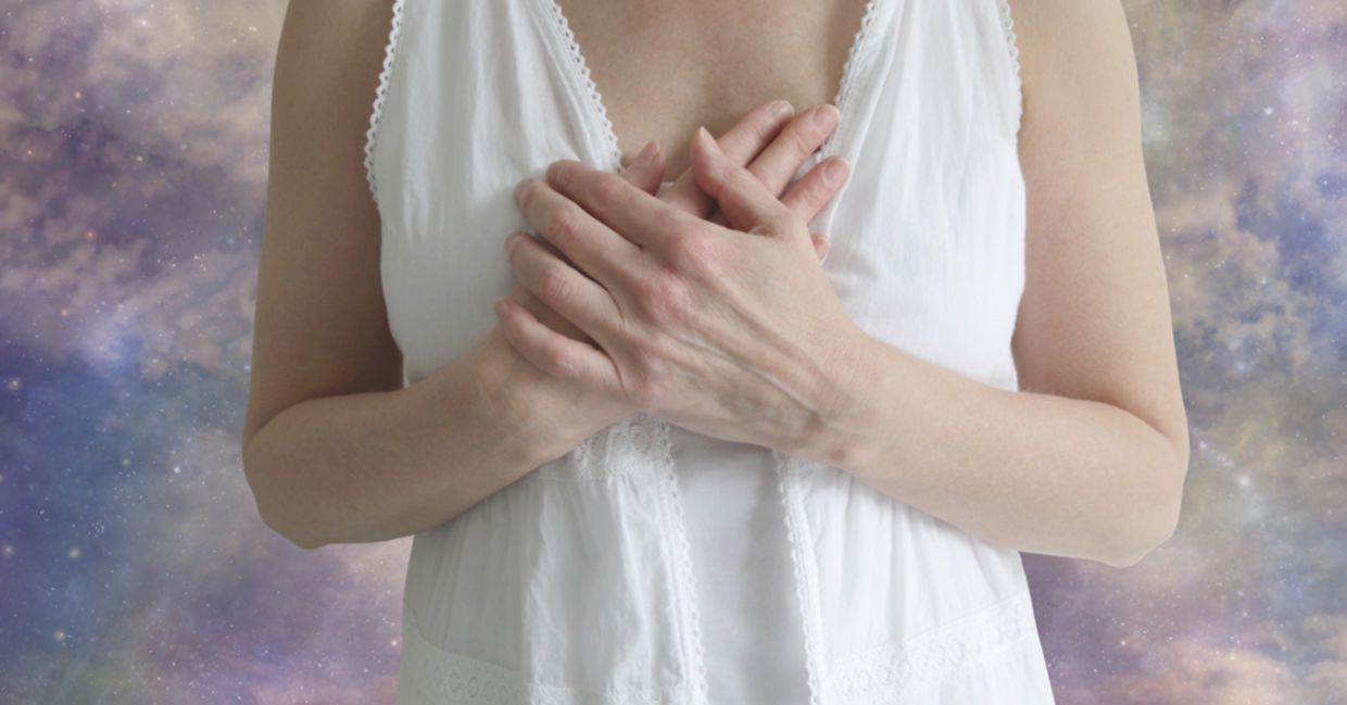 An emotional empath holds her hands to her heart, feeling the emotions of those around her. An emotional empath holds her hands to her heart, feeling the emotions of those around her.