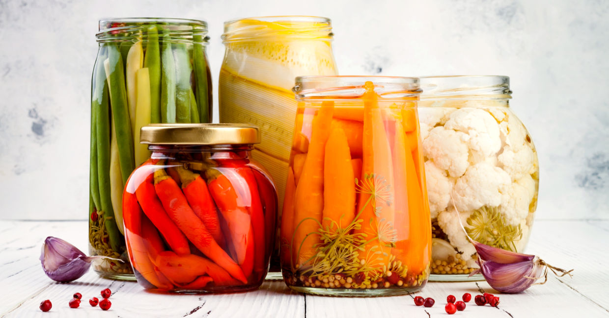 An appetizing selection of marinated pickled vegetables in glass jars. An appetizing selection of marinated pickled vegetables in glass jars.
