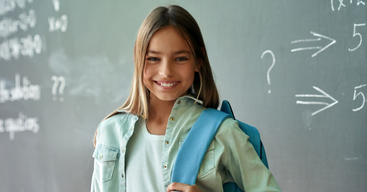 Smiling schoolgirl poses in her classroom Smiling schoolgirl poses in her classroom