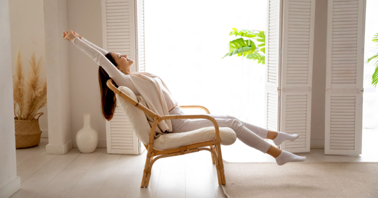 Woman breathing in the fresh air after opening the window