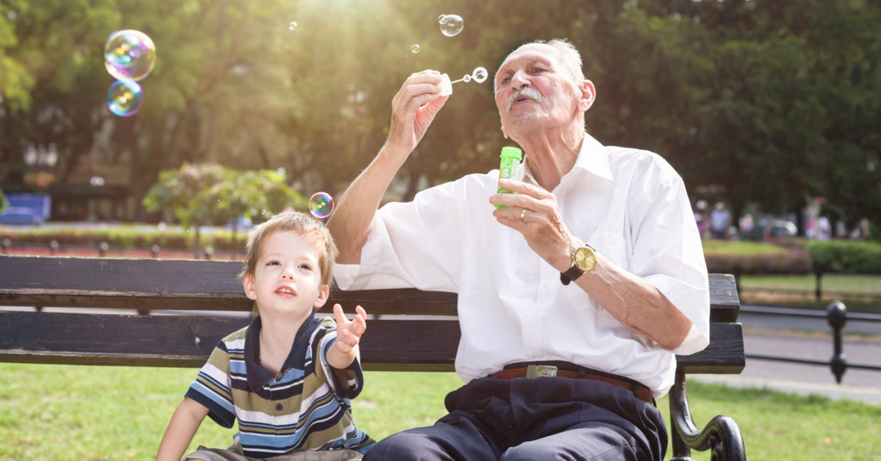 A young boy and an old man blowing bubbles. A young boy and an old man blowing bubbles.